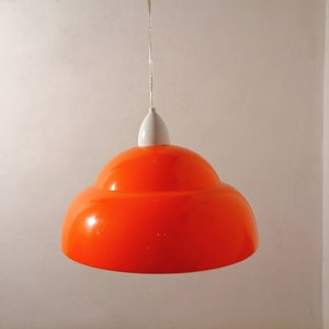 May include: A bright orange and white pendant light with a rounded, layered shade.