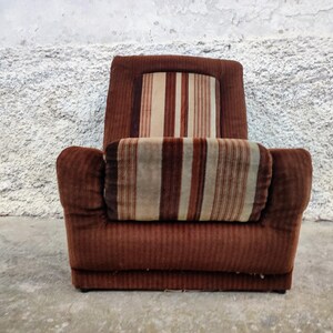 May include: A brown striped armchair with a high back and thick padding. The chair has a brown corduroy fabric with a striped pattern in shades of brown, beige, and white.