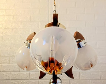 May include: A vintage chandelier with three white glass globes and a brown wooden base. The globes have a textured, amber-coloured interior.
