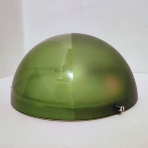 Puede incluir: Una lámpara de techo de cúpula de vidrio verde con un acabado liso y brillante en una mitad y un acabado esmerilado en la otra mitad.