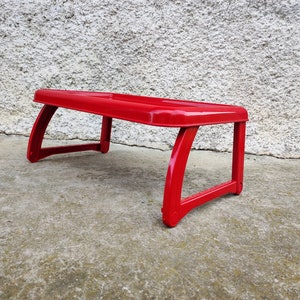 K&ouml;nnte beinhalten: Ein leuchtend roter, rechteckiger Scho&szlig;tisch mit gebogenen Beinen. Der Tisch besteht aus einem gl&auml;nzenden Material und ist daf&uuml;r konzipiert, auf dem Scho&szlig; einer Person zu liegen. Der Tisch ist etwa 46 cm lang und 30 cm breit.