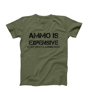 May include: A green t-shirt with black text that reads "Ammo is Expensive. Do not expect a warning shot."