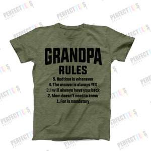 May include: Green t-shirt with black text that reads "Grandpa Rules" and a list of rules: "5. Bedtime is whenever", "4. The answer is always YES", "3. I will always have your back", "2. Mom doesn't need to know", "1. Fun is mandatory".