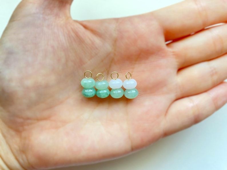 May include: Four small, beaded earrings with gold-colored hoops. The earrings are made of two stacked, round beads. The beads alternate between light green and white. The earrings are displayed on a light-colored background.