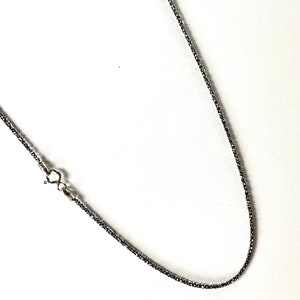 May include: A silver chain necklace with a lobster clasp.
