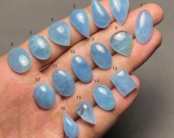 Puede incluir: Una colección de dieciséis gemas de aguamarina en varias formas, incluyendo ovaladas, de lágrima y rectangulares. Las gemas son de color azul claro y están numeradas.