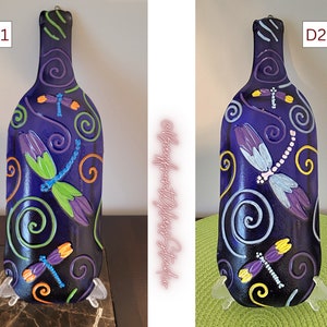 Puede incluir: Dos bandejas de servir de botella de vino de vidrio morado con diseños de libélulas. Las bandejas están decoradas con remolinos de pintura azul, verde, amarilla y naranja. Las bandejas están etiquetadas como D1 y D2.