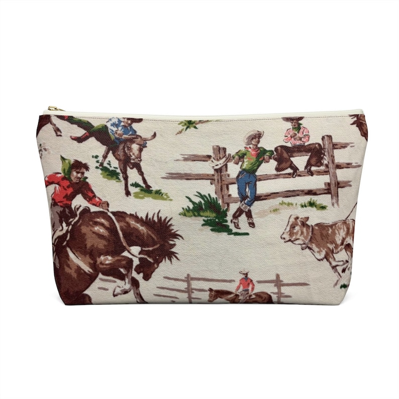Puede incluir: Una bolsa blanca con cremallera con un patr&oacute;n repetido de vaqueros montando caballos y toros. Los vaqueros llevan ropa y sombreros coloridos. El fondo es beige claro con una valla marr&oacute;n y hierba verde.
