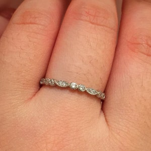 May include: A delicate silver band with small round diamonds set in a leaf pattern.
