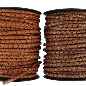 May include: Two spools of brown leather cord, each wound tightly with a braided design.