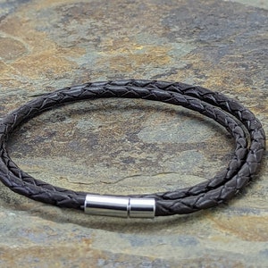 May include: A brown leather bracelet with a silver magnetic clasp.