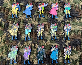 Peut inclure: Un ensemble de 12 épingles en émail représentant un personnage de dessin animé en costume jaune et bleu tenant un personnage féminin dans une variété de robes. Les épingles sont disposées en grille sur un fond vert et marron.
