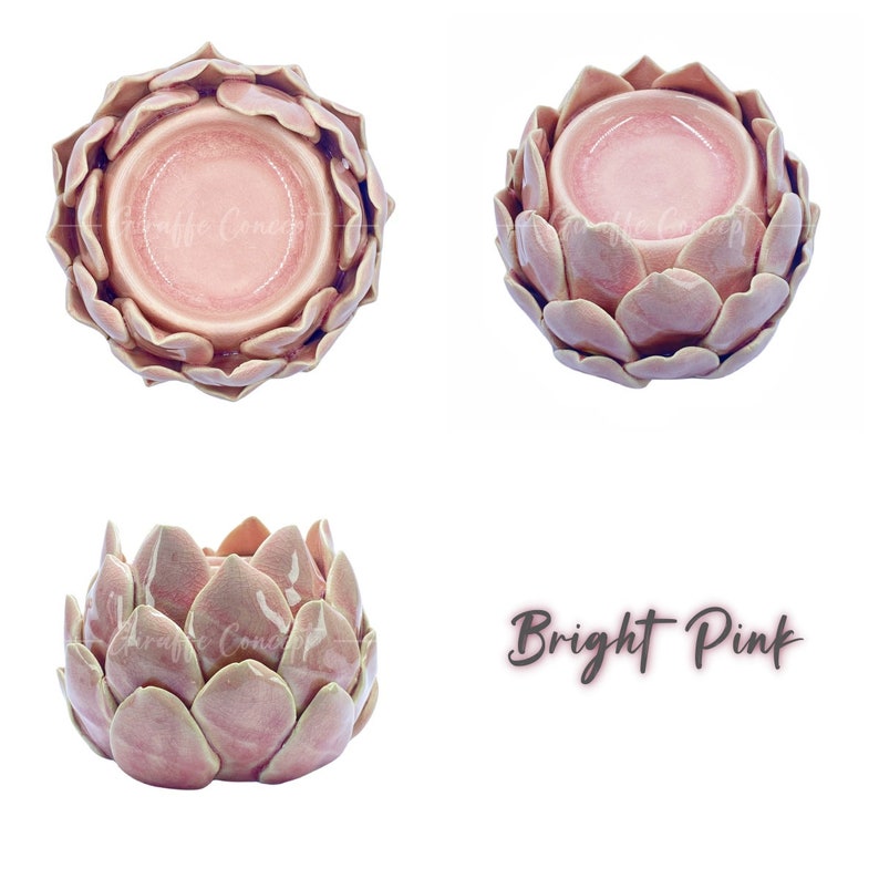 May include: A bright pink ceramic wax melt burner shaped like a flower. The burner has a round well in the center for holding a wax melt.