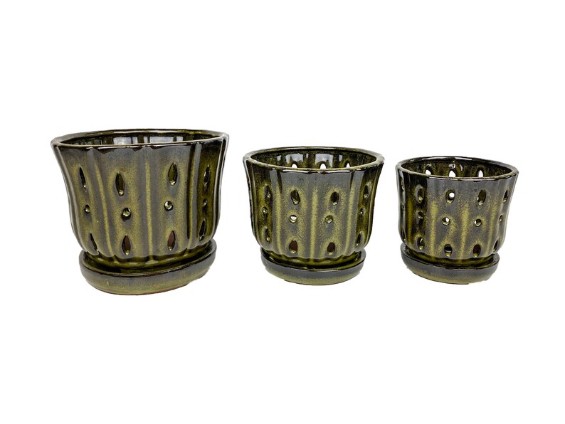 May include: Set of three green ceramic planter pots with drainage holes and matching saucers. The pots have a textured, ribbed design.