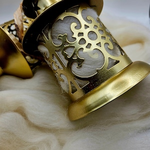 May include: Gold metal lantern with a decorative cutout design. The lantern is filled with white cotton batting.