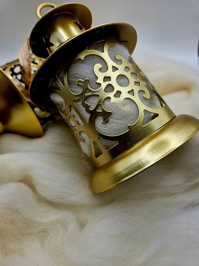 May include: Gold metal lantern with a decorative cutout design. The lantern is filled with white cotton batting.