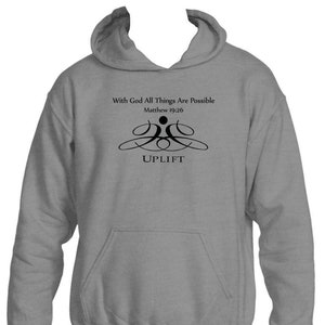 May include: A grey hooded sweatshirt with the text "With God All Things Are Possible" and "Matthew 19:26" printed on the front. The sweatshirt also features a stylised graphic of two people lifting each other up with the word "UPLIFT" printed below.