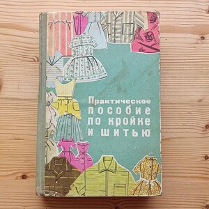May include: A vintage book cover with a teal background and the text "Практическое пособие по кройке и шитью" (Practical Guide to Cutting and Sewing). The cover features illustrations of various clothing items, including dresses, shirts, and skirts, in a variety of colors and patterns.