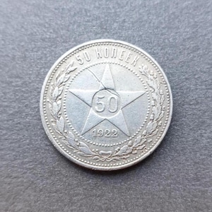 Op de afbeelding: Een zilverkleurige ronde munt met een vijfpuntige ster in het midden waarin het getal 50 staat. De tekst 50 KOPEEK staat langs de bovenrand gegraveerd en het jaartal 1922 staat onder de ster, omringd door een decoratieve kransrand.