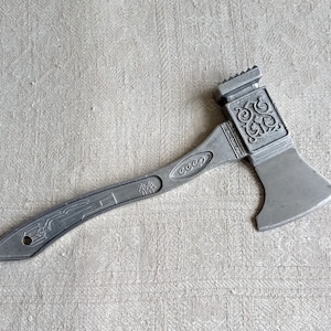 Könnte beinhalten: Ein silberner Fleischklopfer aus Metall mit einem Hammerkopf und einem Griff, auf dem das Wort "CCCP" eingraviert ist.