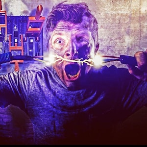 Pode incluir: Um homem está segurando dois fios elétricos com faíscas saindo deles. Ele está gritando com a boca aberta. O fundo é uma imagem desfocada de uma parede.