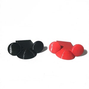 May include: Two 3D printed Mickey Mouse ear phone holders, one black and one red.