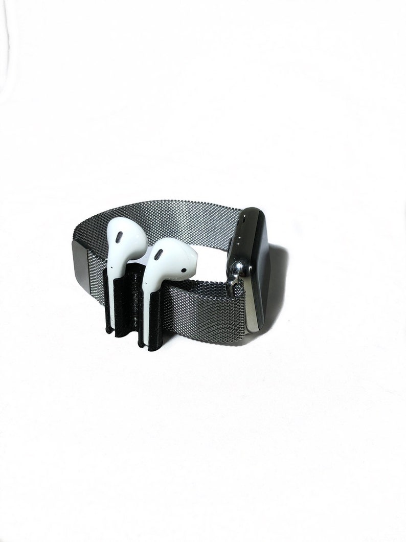 K&ouml;nnte beinhalten: Eine schwarze und silberne Apple Watch mit einem Metallband und einem schwarzen 3D-gedruckten Halter f&uuml;r AirPods.