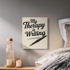 Puede incluir: Impresión en lienzo con el texto "My Therapy is Writing" en escritura negra, acompañada de una ilustración de pluma negra. La obra de arte se muestra sobre un fondo neutro, ideal para un espacio de escritura.