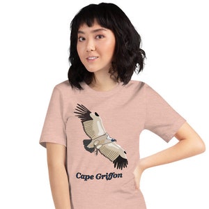 May include: A pink heather t-shirt featuring a graphic of a Cape Griffon in flight. The text "Cape Griffon" is printed in blue below the bird.