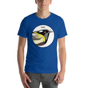 May include: A royal blue t-shirt featuring a white circle with a colourful illustration of a bird and the word "Hihi" above it.