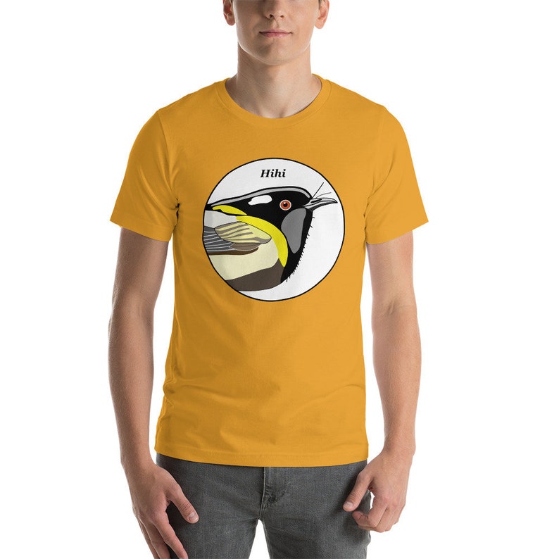 May include: A yellow short-sleeved t-shirt with a circular graphic of a black and yellow bird with the text "Hihi" above the bird.