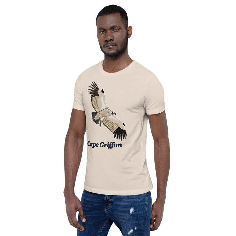May include: A beige t-shirt featuring a graphic of a Cape Griffon vulture in flight. The text "Cape Griffon" is printed below the bird.