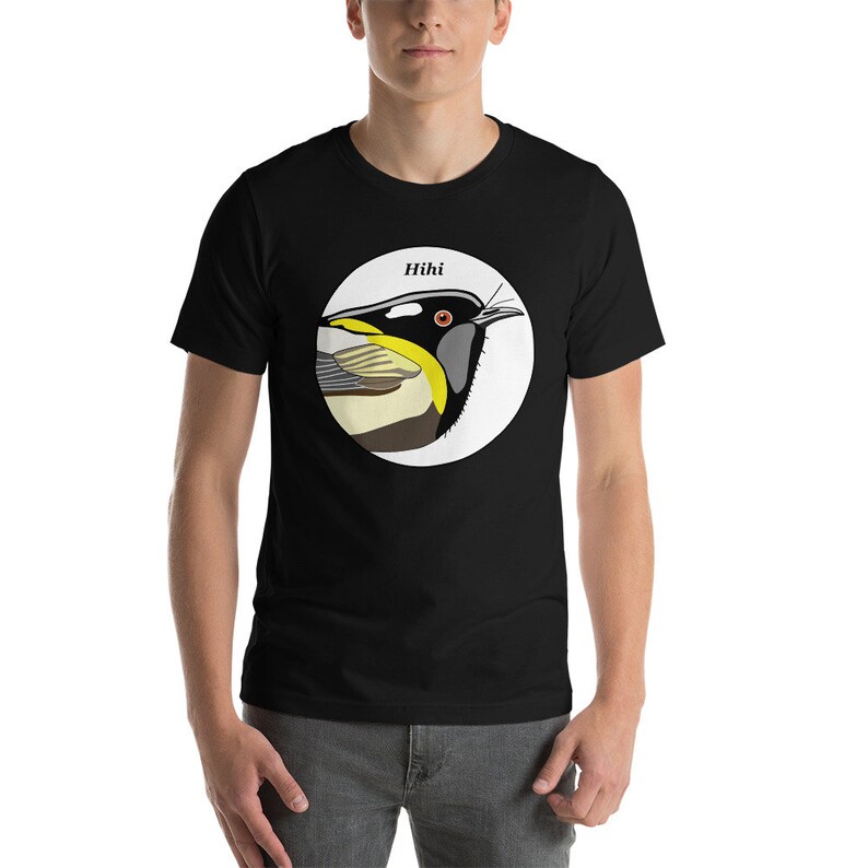 May include: Black t-shirt with a white circle featuring a colourful illustration of a bird with the word "Hihi" above it.