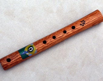 Puede incluir: Una flauta de madera con un diseño de pájaro en el cuerpo. La flauta tiene seis agujeros para los dedos y está firmada "JF".