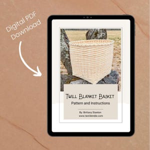 May include: A digital PDF download displayed on a tablet. The image shows a woven basket with the text "Twill Blanket Basket Pattern and Instructions" and the website address www.textileindie.com.
