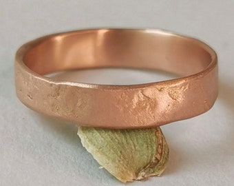 Op de afbeelding: Een roségouden ring met een getextureerd oppervlak. De ring rust op een klein, lichtgroen object tegen een witte achtergrond. De band van de ring is ongeveer 4 mm breed.