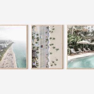 May include: Three framed photographs of a beach scene. The first photo shows an aerial view of a beach with white buildings and a blue ocean. The second photo shows an aerial view of a beach with palm trees and a road. The third photo shows a pool with lounge chairs and palm trees.
