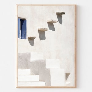 May include: A white building with a blue door and a set of stone steps leading up to it. The steps are made of flat, rectangular stones.