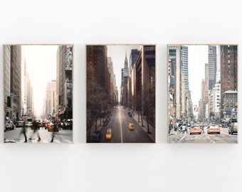 May include: Three framed photographs of a city street in New York City. The photos show a wide street with tall buildings on either side. The street is lined with trees and there are yellow taxis driving down the street.
