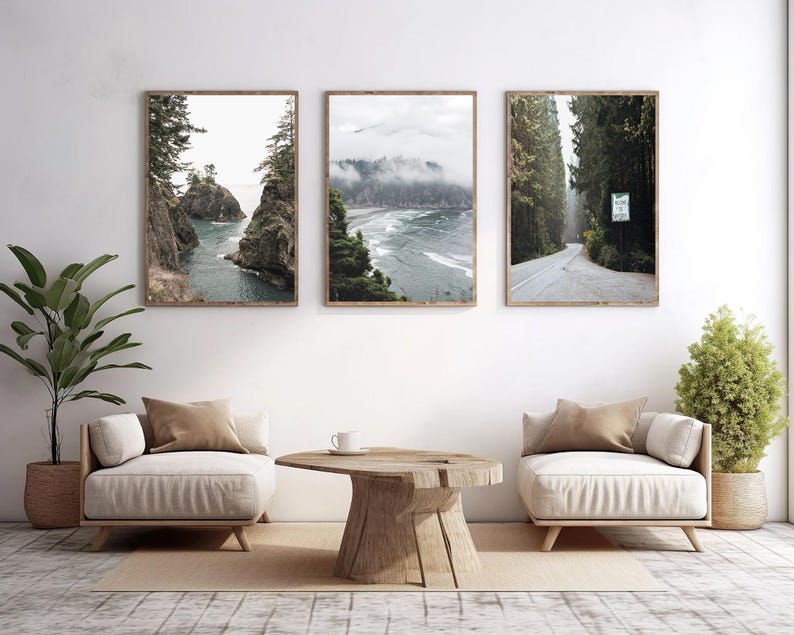 May include: Three framed landscape prints depicting coastal and forest scenes. The first shows a rocky coastline with turquoise water. The second features a misty beach. The third shows a road through a forest.