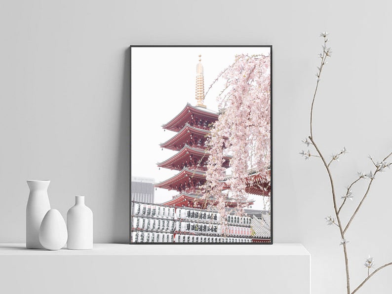 May include: A framed photograph of a red pagoda with a cherry blossom tree in the foreground. The pagoda is a traditional Japanese architectural structure with multiple tiers. The cherry blossom tree is in full bloom, with delicate pink flowers.