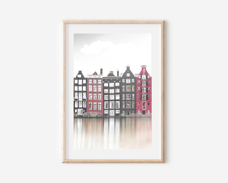 May include: A photograph of a row of colorful buildings reflected in a canal. The buildings are a mix of red, black, and white. The water is calm and reflects the buildings.
