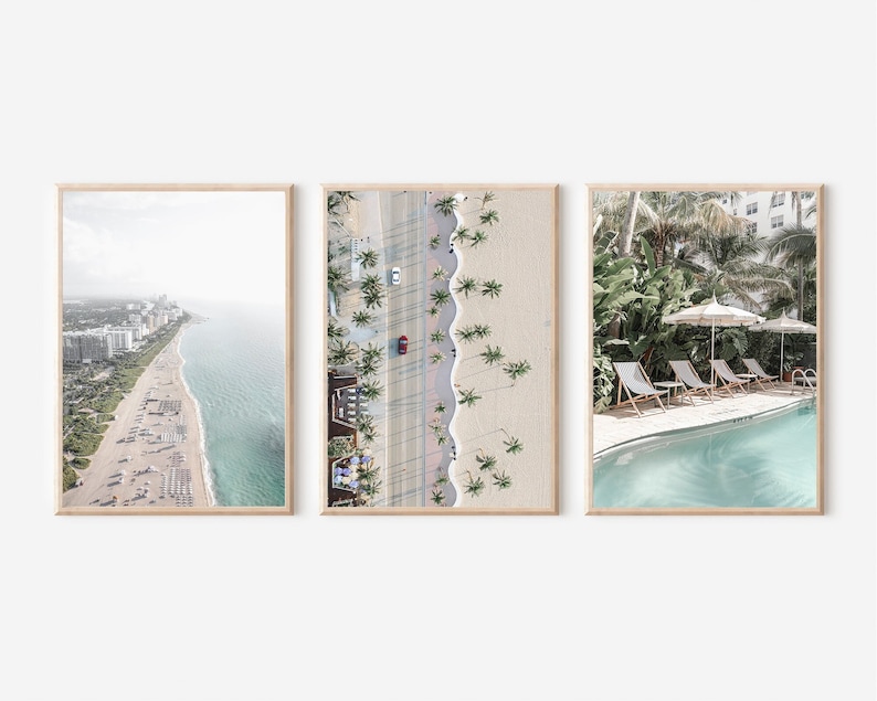 May include: Three framed photographs of a beach scene. The first photo shows an aerial view of a beach with white buildings and a blue ocean. The second photo shows an aerial view of a beach with palm trees and a road. The third photo shows a pool with lounge chairs and palm trees.