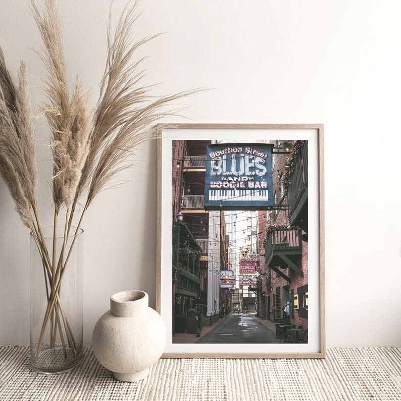 Puede incluir: Una fotograf&iacute;a enmarcada de un callej&oacute;n estrecho en Nueva Orleans, Luisiana. El callej&oacute;n est&aacute; bordeado de edificios de ladrillo y tiene un letrero que dice "Bourbon Street Blues Band & Boogie Bar".