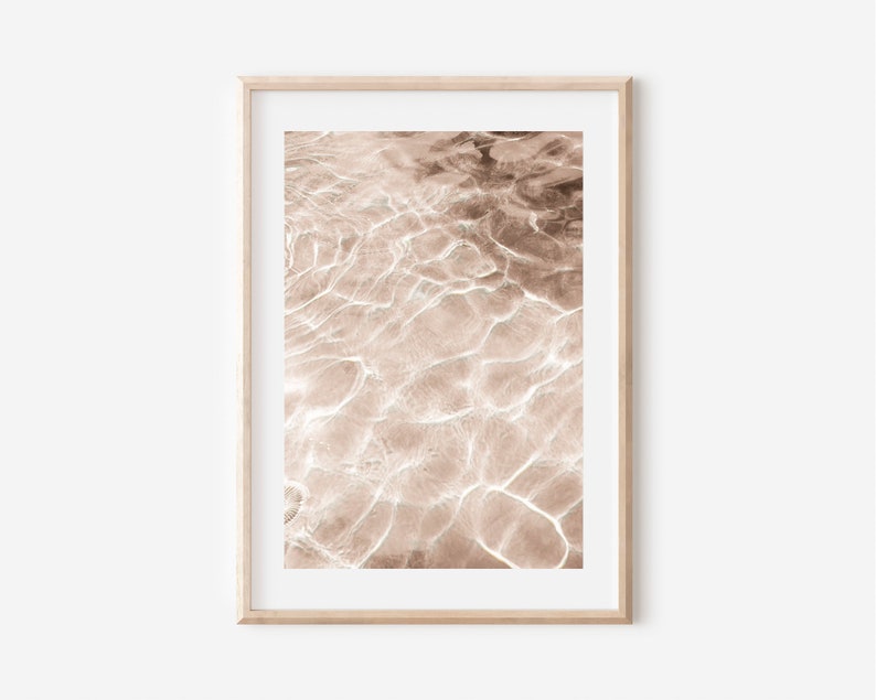 May include: Abstract photograph of rippling water in shades of brown and white. The water is calm and still, with a soft, ethereal glow.