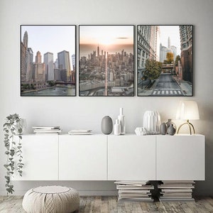 May include: Three framed cityscapes with a modern minimalist aesthetic. The images feature a cityscape with a river, a cityscape with a sunset, and a street scene with a crosswalk.