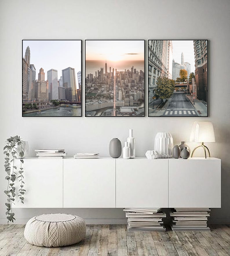 May include: Three framed cityscapes with a modern minimalist aesthetic. The images feature a cityscape with a river, a cityscape with a sunset, and a street scene with a crosswalk.