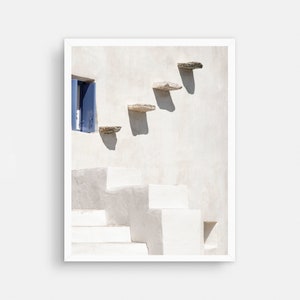 May include: A white building with a blue door and a set of stone steps leading up to it. The steps are made of flat, rectangular stones.