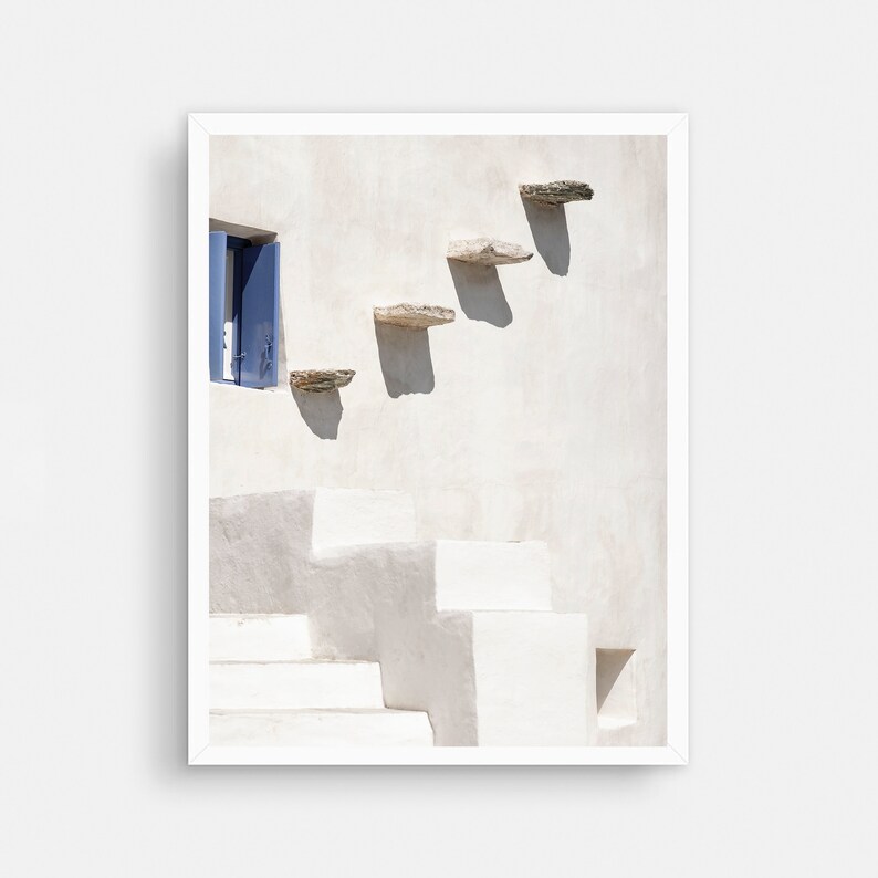 May include: A white building with a blue door and a set of stone steps leading up to it. The steps are made of flat, rectangular stones.