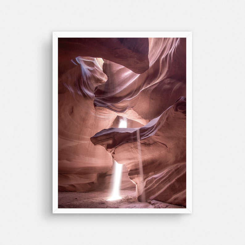 May include: A narrow canyon with smooth, red rock walls. A beam of light shines through a crack in the ceiling, illuminating the canyon floor.